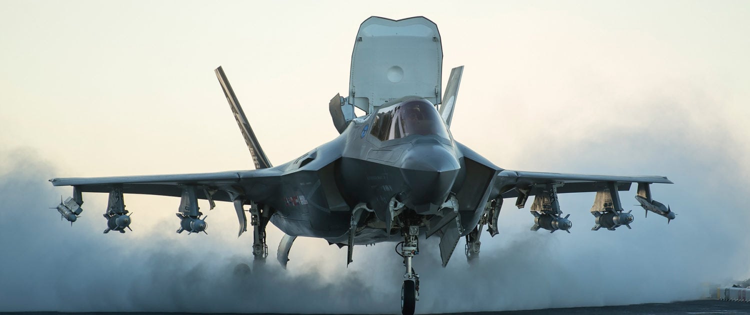 DEFENCE-1500×630 F-35 fighter jet taking off, stealth military aircraft soaring into the sky.