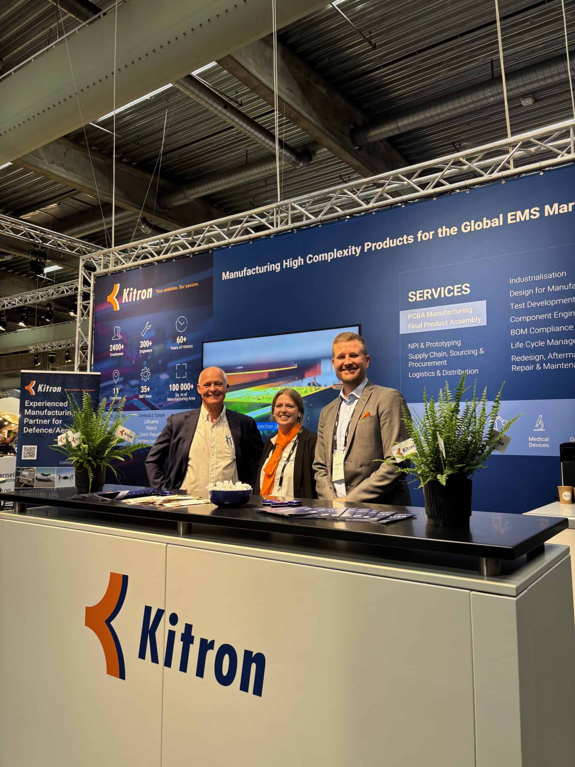 Innovative manufacturing booth with team members showcasing high-tech aerospace products at Confidee conference.